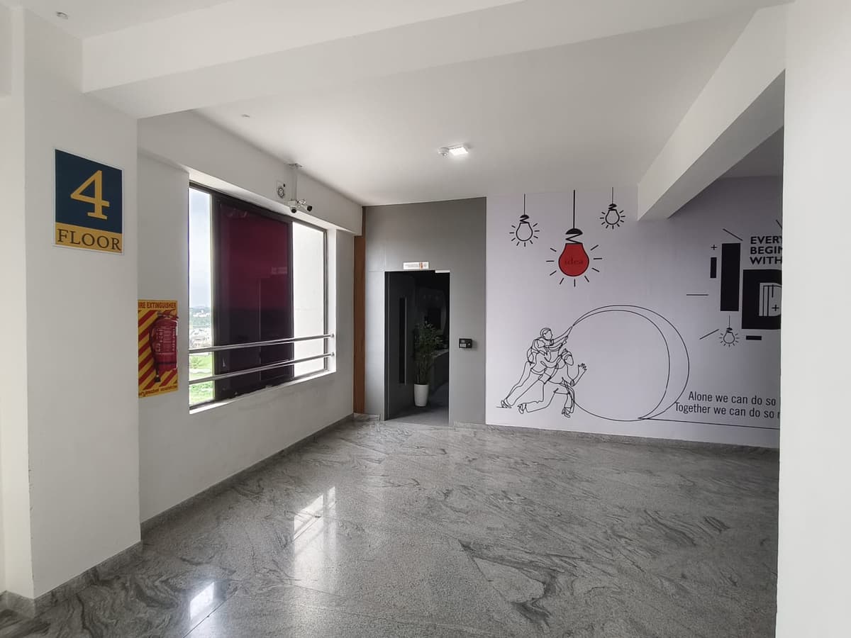 The fourth-floor lobby, with a granite floor, a large window and a wall mural of hanging light bulbs and two figures climbing together
